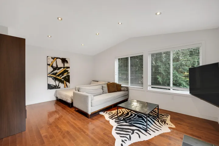 Living room featuring recessed lighting, wood finished floors, and vaulted ceiling