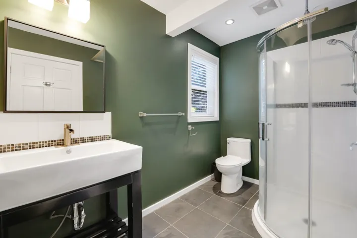Full bathroom with tile patterned floors, a shower stall, and tasteful backsplash