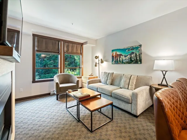 Carpeted living area with a fireplace and baseboard heating