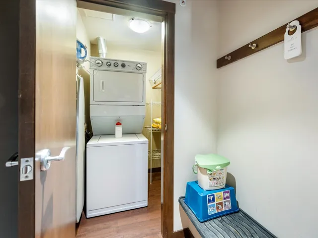 Laundry area featuring estacked washer and dryer and wood finished floors