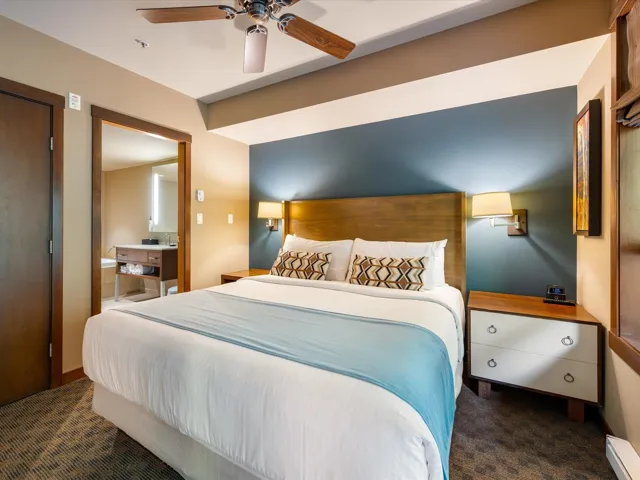 Bedroom with dark carpet, a baseboard heating unit, and a ceiling fan