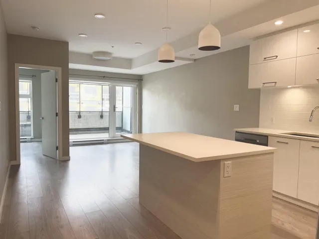 Kitchen featuring backsplash, modern cabinets, light countertops, light wood-style flooring, and recessed lighting