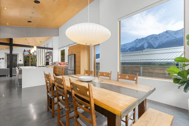 Dining space featuring concrete floors, a mountain view, and a high ceiling