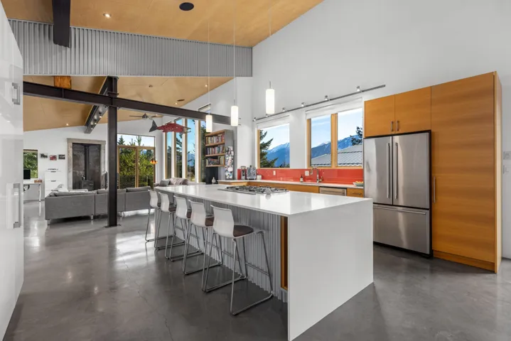 Kitchen featuring concrete flooring, wood finish cabinets, a breakfast bar, stainless steel appliances, and a mountain view