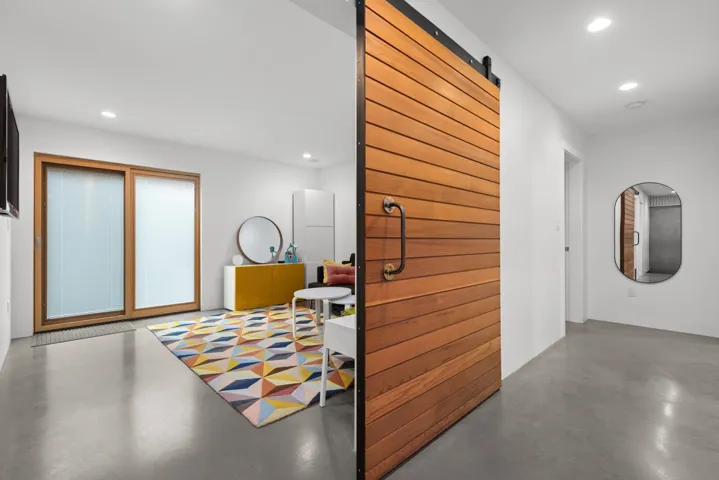 Corridor with finished concrete floors, a barn door, and recessed lighting