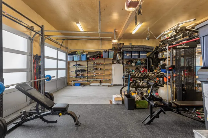 Garage featuring freestanding refrigerator and a garage door opener