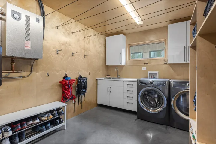 Laundry room featuring finished concrete floors, cabinet space, and independent washer and dryer