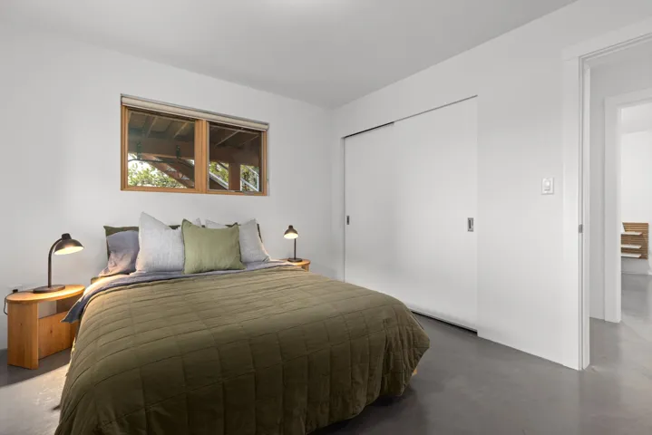 Bedroom with concrete flooring and a closet