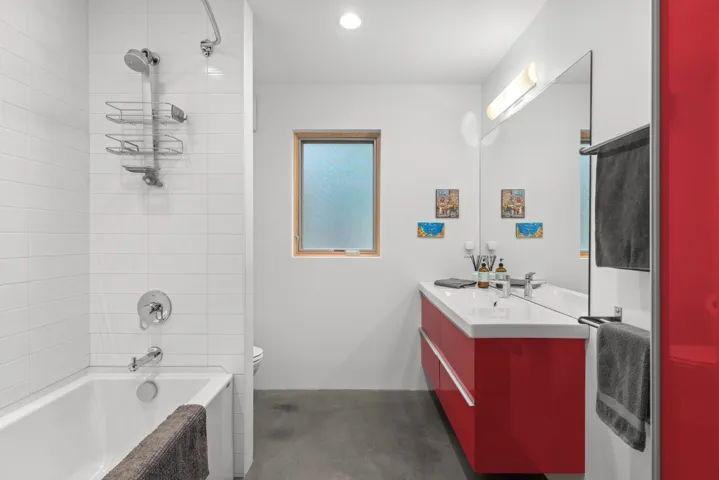 Bathroom with vanity, tub / shower combination, and finished concrete floors