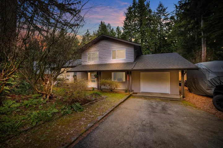 Two-story residence featuring light gray siding, a dark asphalt shingle roof, and an attached single-car garage