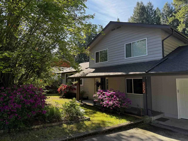 Two-story residence featuring grey horizontal siding and a dark shingle roof