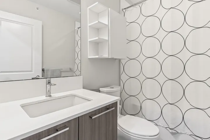 Bathroom featuring a wood-finish vanity with an integrated rectangular sink, chrome faucet, and white countertop