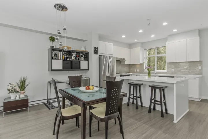 Open-concept kitchen and dining area featuring light wood-finish flooring