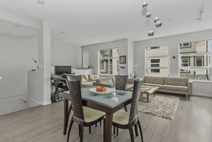 Spacious open-concept living area featuring wood-finish flooring, multiple windows, and recessed lighting