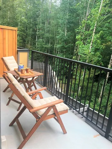 Private outdoor space with a black metal railing and wood-tone privacy screen