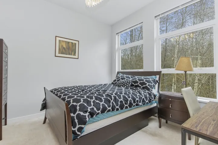 Bright interior space featuring multiple large windows, light wall tones, and neutral carpeting