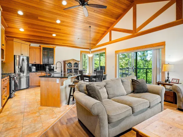 Living area with wood ceiling, a ceiling fan, recessed lighting, and high vaulted ceiling