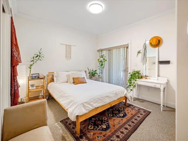 Carpeted bedroom with ornamental molding and baseboards