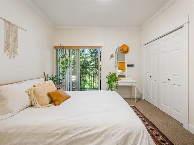 Bedroom with crown molding, carpet, and a closet