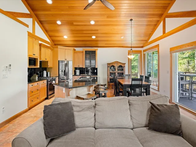 Living area featuring vaulted ceiling, wood ceiling, ceiling fan, recessed lighting, and baseboards