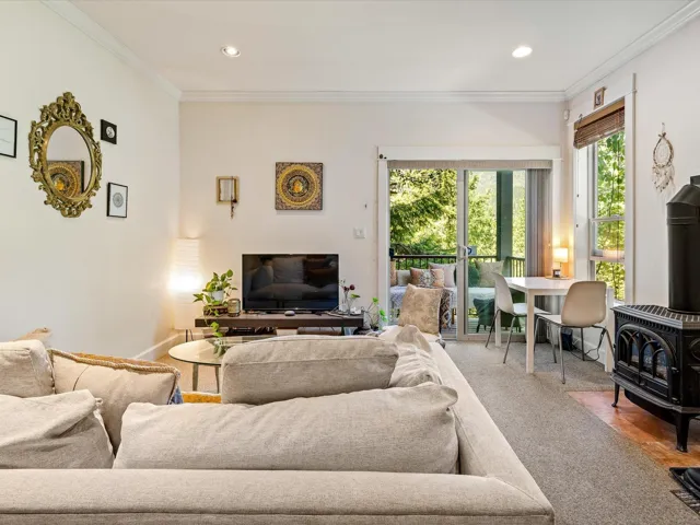 Living room with a wood stove, crown molding, recessed lighting, and carpet