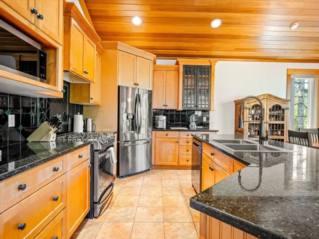 Kitchen featuring stainless steel appliances, wooden ceiling, a sink, recessed lighting, and backsplash