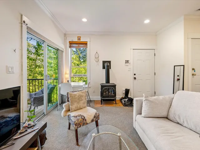 Living room featuring a wood stove, ornamental molding, recessed lighting, and wood finished floors