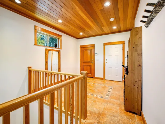 Hallway with an upstairs landing, recessed lighting, wooden ceiling, baseboards, and light tile patterned floors