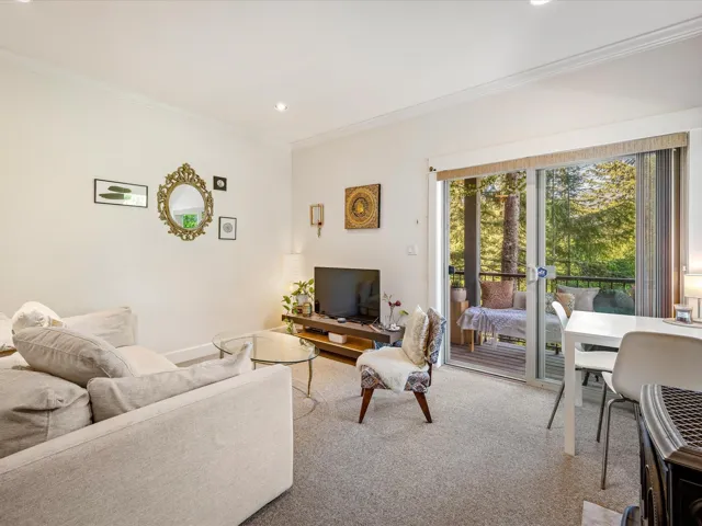 Carpeted living area with crown molding, recessed lighting, and baseboards