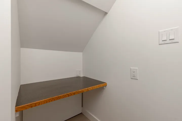 Unfurnished office with vaulted ceiling and baseboards