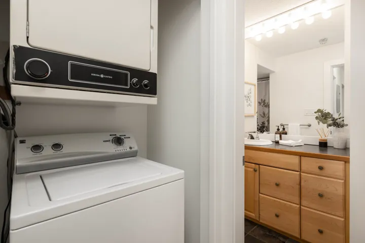 Laundry room with stacked washing machine and dryer