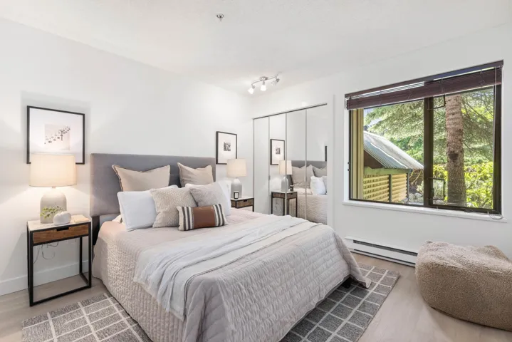 Bedroom with a baseboard heating unit, wood finished floors, and a textured ceiling