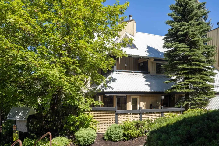 View of front of property with a metal roof, a chimney, and board and batten siding