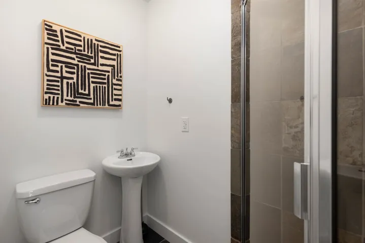 Full bathroom with toilet and a shower stall