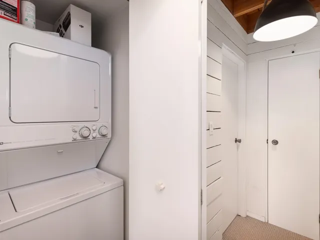 Laundry room with stacked washing machine and dryer