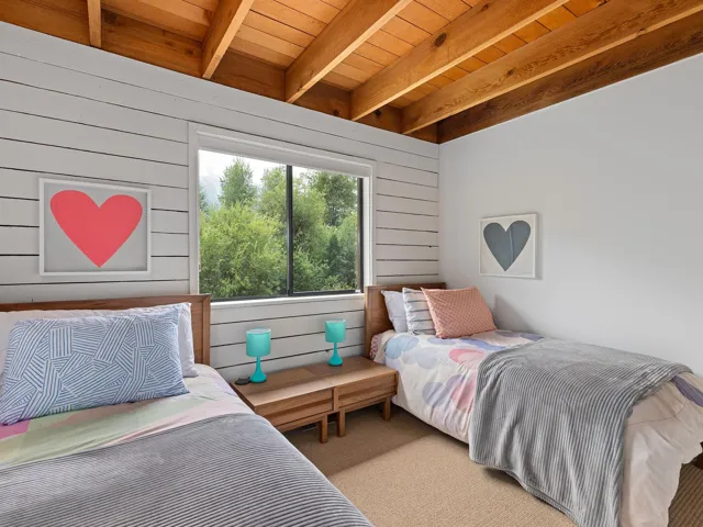 Bedroom featuring carpet flooring, wood walls, and a wood ceiling with exposed beams