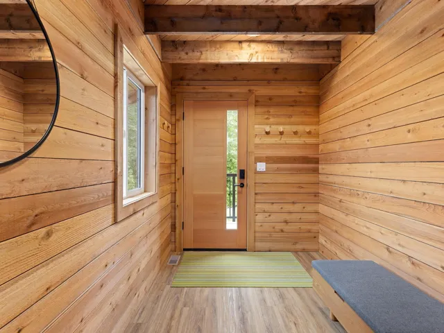 Foyer with wood finished floors, a wood ceiling with exposed beams, a sauna / steam room, and wooden walls
