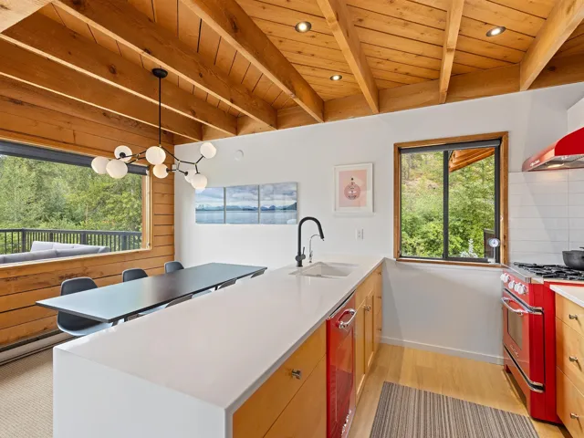 Kitchen with a peninsula, hanging light fixtures, range with gas cooktop, light wood-style flooring, and recessed lighting