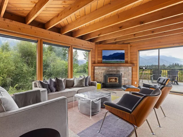 Sunroom featuring a wooden ceiling with exposed beams, wooden walls, and carpet