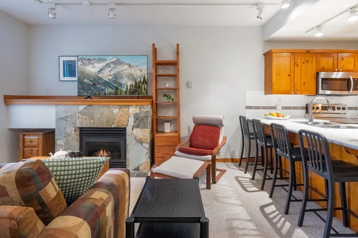 Stone-faced fireplace with a wood mantelpiece and track lighting