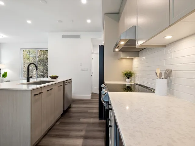 Kitchen featuring visible vents, stainless steel appliances, a sink, extractor fan, and backsplash