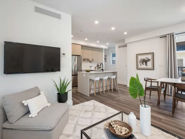 Living area with recessed lighting, visible vents, plenty of natural light, and wood finished floors