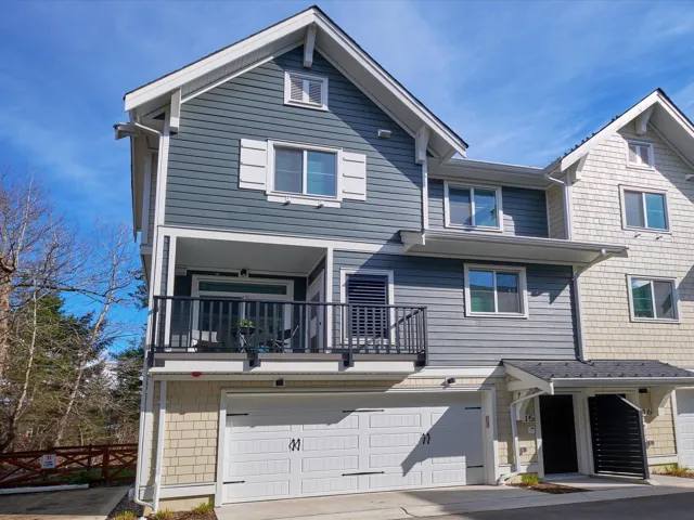 View of property with a balcony, driveway, and a garage