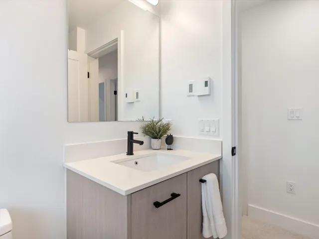 Bathroom with vanity, toilet, and baseboards