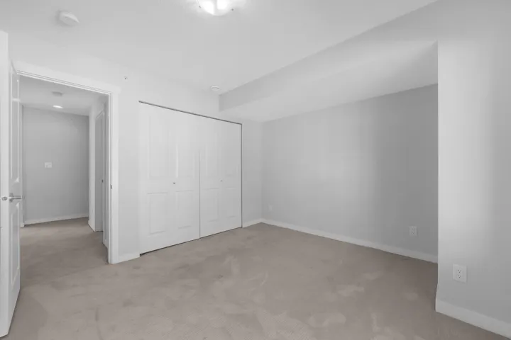 Spacious open-concept living area with wood-finish flooring, a kitchen island with built-in microwave, and large windows
