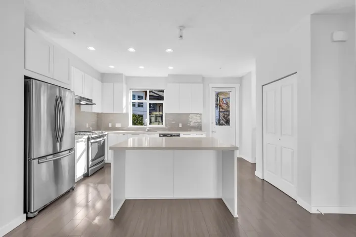 Spacious garage featuring a concrete floor, bright white walls, and a paneled garage door with upper window inserts