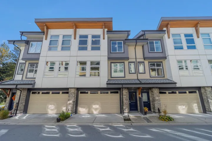 Modern townhome exterior with mixed material siding, architectural rooflines, and integrated landscaping