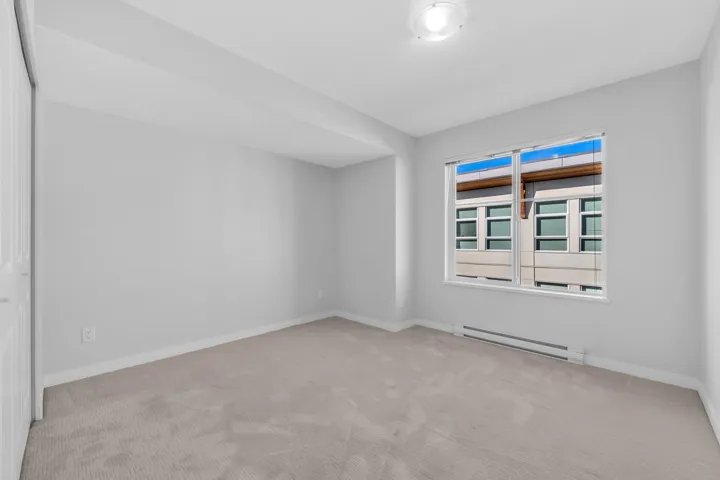 Modern kitchen featuring white shaker-style cabinetry, a large center island with quartz countertop, stainless steel appliances including a dishwasher, and recessed ceiling lighting