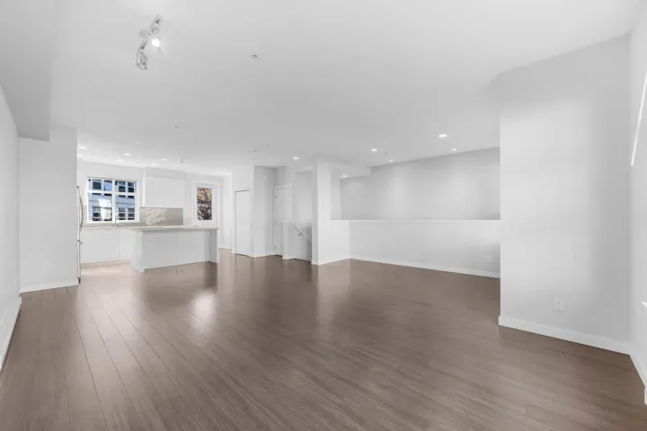 Spacious garage featuring a concrete floor, multiple entry doors, and overhead lighting