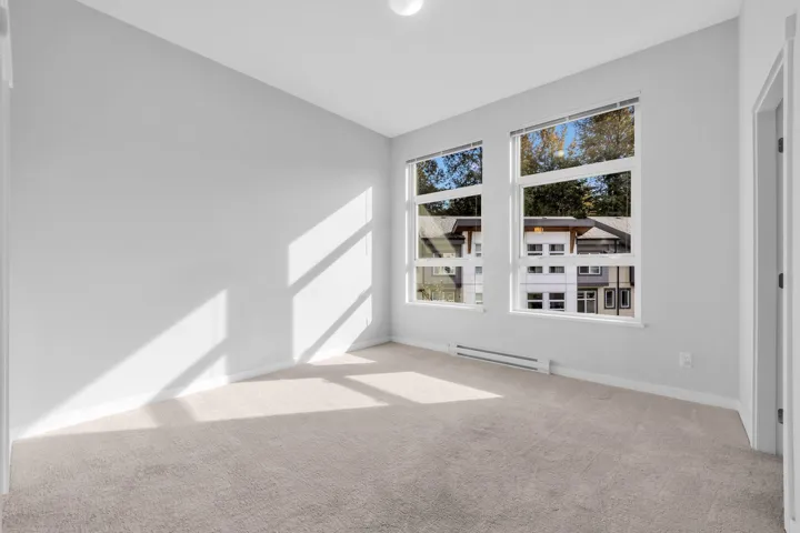 Expansive open-concept space featuring wood-finish flooring, recessed lighting, and a kitchen with white cabinetry and a breakfast bar